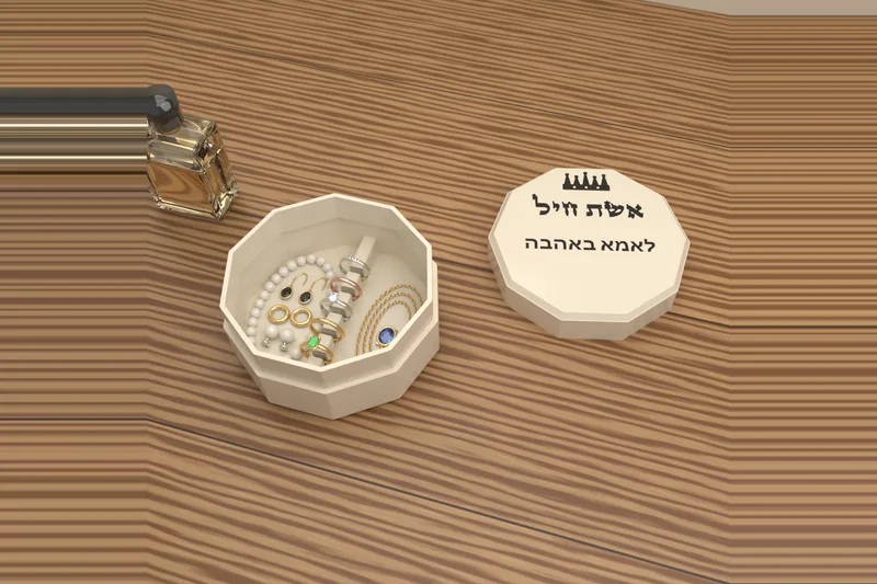 קופסת התכשיטים «אשת חיל» פתוחה ובה טבעות, שרשרת, צמיד פנינים ועגילים, והמכסה עם «לאמא באהבה» לידה