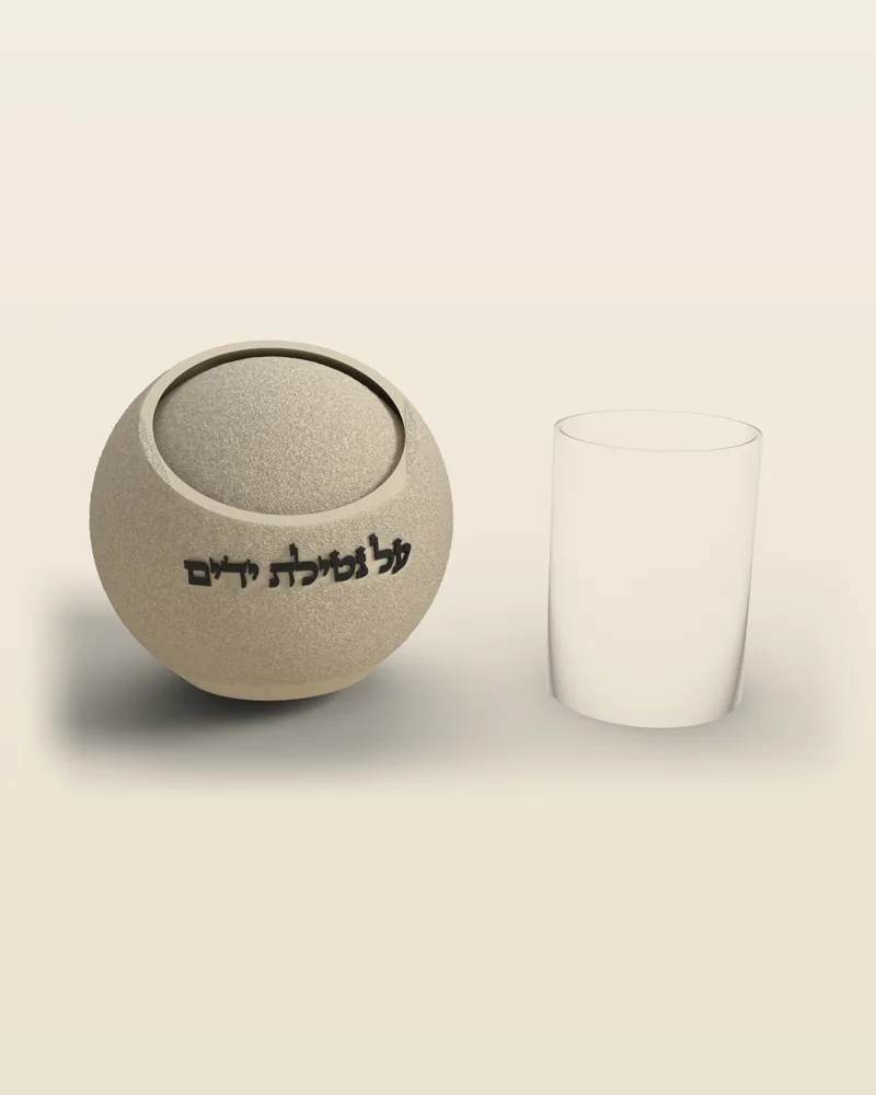 נטלה כדורית בעיצוב מיוחד בצבע שמנת, ליד כוס להמחשת הגודל