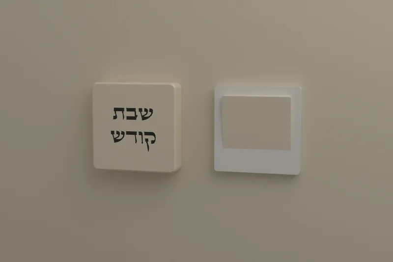 כיסוי מתג «שבת קודש» בצבע שמנת על הקיר, ליד מתג בלי כיסוי